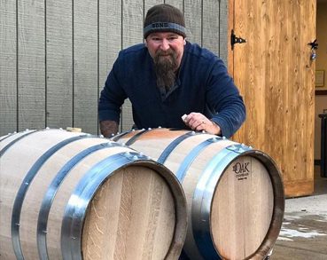man with wine barrels